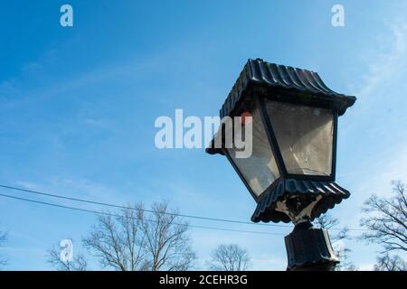 An Old-Fashioned Black Metal Lamp Post on a Clear Blue Sky Stock Photo