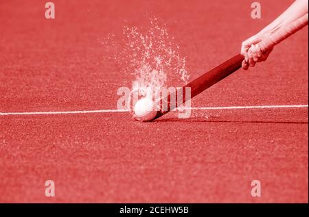 Hockey player with ball in attack playing field hockey game. Red color filter Stock Photo