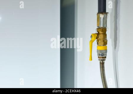 Gas Isolating Valve on pipe in house. The yellow handle lever ball valve is a full-bore brass ball valve, suitable for use with Natural Gas and LPG. S Stock Photo