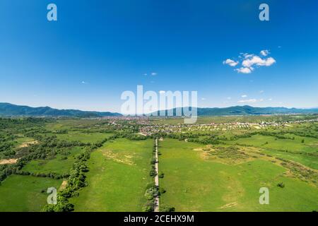 Panoramic view of mountains valley. Green field and trees in spring on a sunny day. View from above Stock Photo
