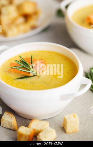 Fish cream soup with Salmon, cheese, Potatoes and herbs in white Soup Bowls. Stock Photo