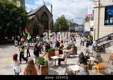 Cardiff, Wales, UK - Tuesday 1st September 2020 - Extinction Rebellion ( XR ) protesters march through the city centre of Cardiff past visitors enjoying an open air cafe, protesting against climate change and the future of society. Photo Steven May / Alamy Live News Stock Photo