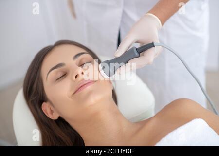 Pretty young woman enjoying professional beauty procedures Stock Photo