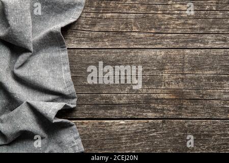 Folded tablecloth over antique wooden table. Top view. Stock Photo