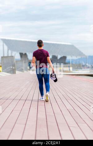 Back view portrait of a casual man walking and looking over shoulder ...