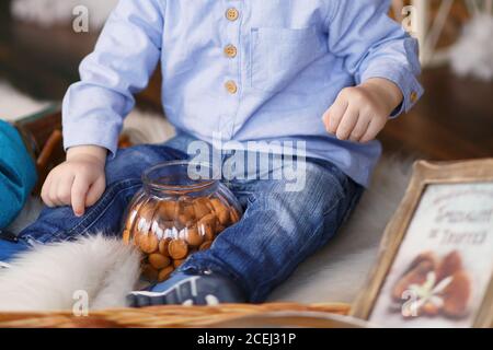 Child's hand reaching out to take cookies from a glass jar Stock Photo