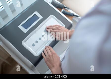Close up picture of medical equipment and human hands on it Stock Photo