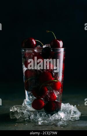 Cherries in a glass with ice on dark background Stock Photo