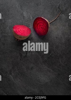 Beetroot cut in half on dark table. Overhead shot with copy space. Minimalism. Stock Photo