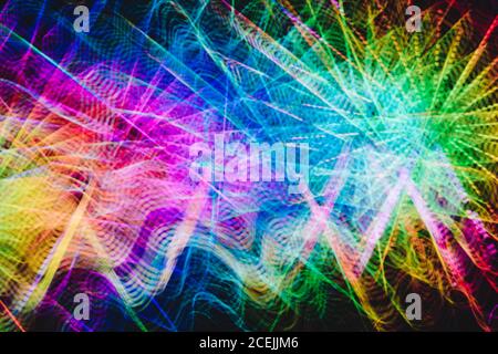 Curvy trails of bright multicolored light on black background Stock Photo