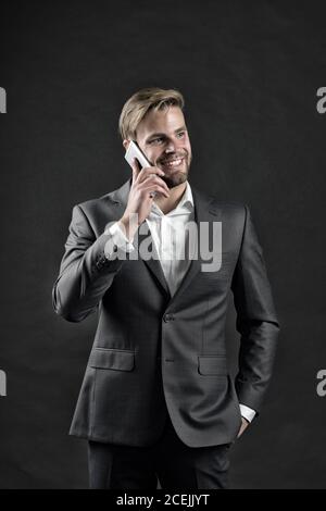 Businessman or ceo fashion. Manager with beard on happy face hold phone. Man in formal outfit with mobile phone. digital marketing and new technology. Business communication and modern life. Stock Photo
