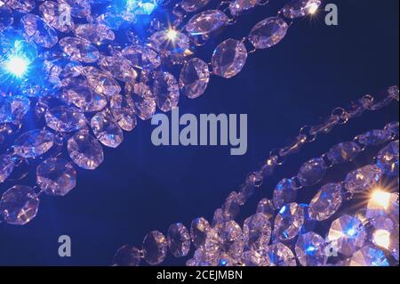 Bright illumination of shiny diamonds in lights on dark blue background Stock Photo