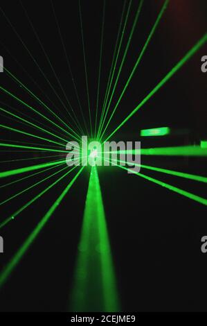 Rays of bright green light shining in dark room Stock Photo