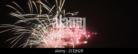From below shot of wonderful vivid fireworks exploding on background of black night sky Stock Photo