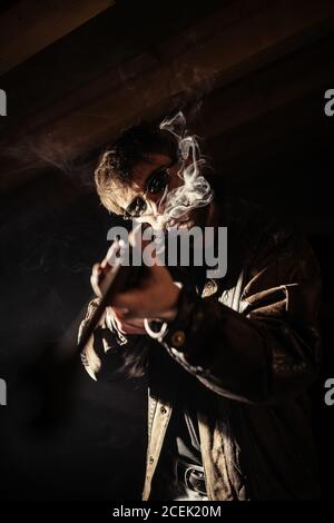 man with shotgun and cigarette Stock Photo