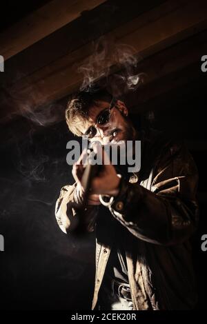 man with shotgun and cigarette Stock Photo