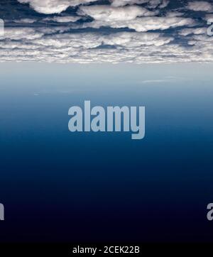 Upside down shot of white clouds and gradient cosmic blue sky Stock Photo