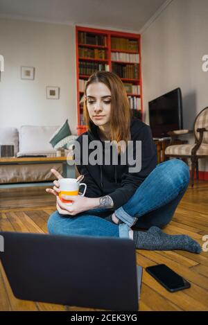 Woman typing on laptop on floor Stock Photo