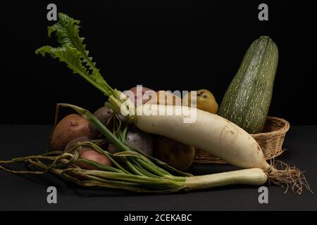 Still life of vegetables in low key. Different types of vegetables in studio shot. Turnip represents selfishness, stealing role and impertinence. Stock Photo