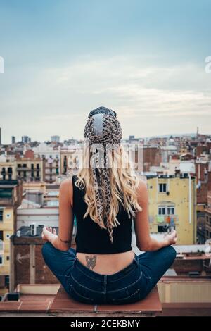 Young Woman sitting on rooftop Stock Photo