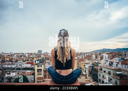 Young Woman sitting on rooftop Stock Photo