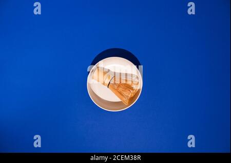 Tea whisk matches with white ceramic bowl. Ingredients for Making a Traditional Japanese Drink. Health and Alternative Medicine. Hard light in the frame. Copy space. Above. High quality photo. Stock Photo