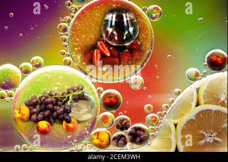 multi-colored photo double exposure of fruit apples grapes lemon nectarine and oil drops in water for background Stock Photo