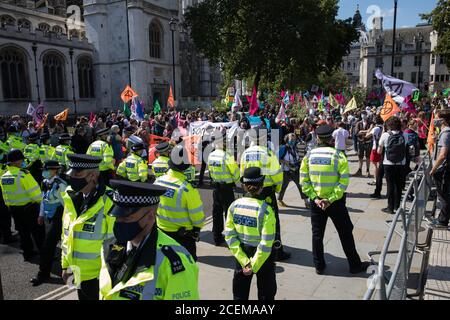 London, UK. 1st September, 2020. Metropolitan Police officers monitor climate activists from Extinction Rebellion occupying roads around Parliament Square during a Back The Bill rally. Extinction Rebellion activists are attending a series of September Rebellion protests around the UK to call on politicians to back the Climate and Ecological Emergency Bill (CEE Bill) which requires, among other measures, a serious plan to deal with the UK’s share of emissions and to halt critical rises in global temperatures and for ordinary people to be involved in future environmental planning by means of a C Stock Photo