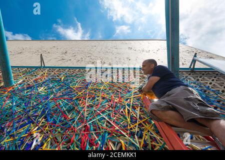 Minneapolis, Minnesota, USA (2016) - Artist Randy Walker at work on a temporary outdoors art installation, entitled Urban Fabric. Stock Photo