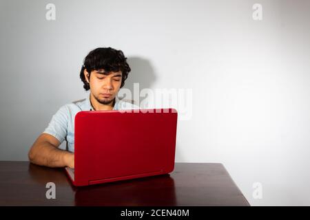 Young hispanic wavy hair man studying from home with a laptop Stock Photo