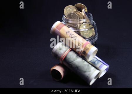 Now and old Indian currencies. 50, 100, 200, 500 rupee notes and coins. Indian currency isolated on black background. Stock Photo