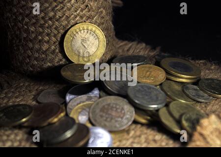 Stock pile of 1, 2, 5, 10 Indian rupee metal coin currency isolated on sack background. Financial, economy, Banking and exchange investment concept. Stock Photo
