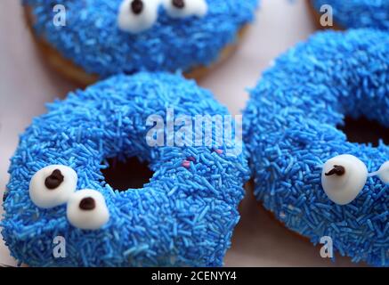 Photo background of delicious sweet doughnuts with faces on display Stock Photo