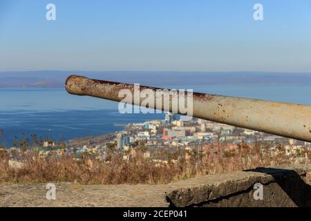 The barrel of the 130-mm gun B-13-3s located on the battery at the top of the Holodilnik hill, against the background of the panorama of the city of V Stock Photo