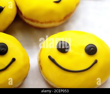Photo background of delicious sweet doughnuts with faces on display Stock Photo
