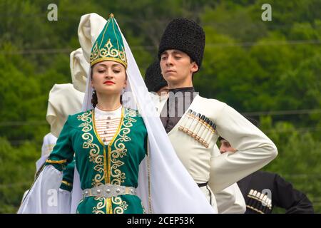 Adygea, RUSSIA - JULY 25 2015: Young guys and girls dancers in traditional Adyghe dresses, dance at an ethnofestival in the Foothills of Caucasus in A Stock Photo