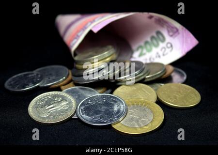 New Indian currency. 2000 rupee note with coins. Indian currency isolated on black background. Stock Photo