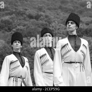 Adygea, RUSSIA - JULY 25 2015: Young guys in Adyghe national costumes dancing traditional dance at an ethnofestival in the Foothills of Caucasus in Ad Stock Photo