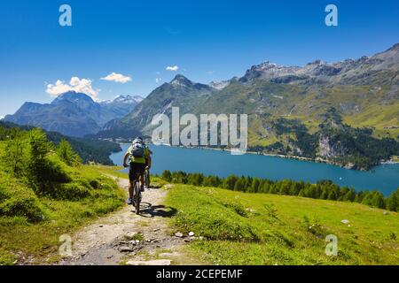 Cycling in the mountains passing through a lake Stock Photo