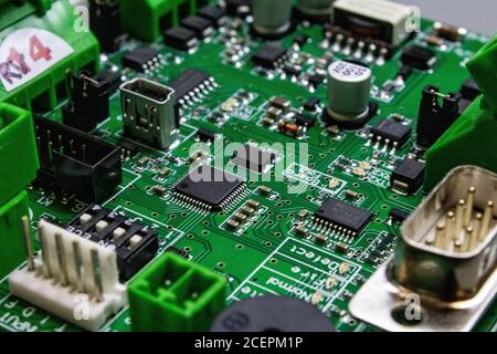 green circuitboard with microcontroller and lots of connectors Stock Photo