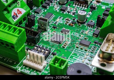 green circuitboard with microcontroller in centre of small city Stock Photo