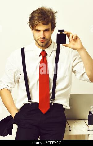 Bearded man, short beard. Caucasian stylish man posing with perfume in shirt and suspenders in studio isolated on white background Stock Photo