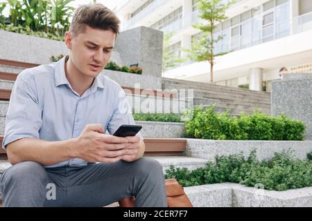 Texting frowning businessman Stock Photo