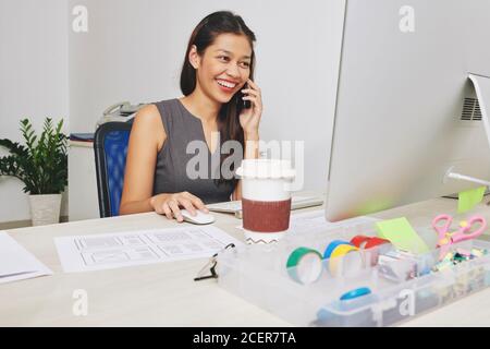 Designer talking on phone with client Stock Photo