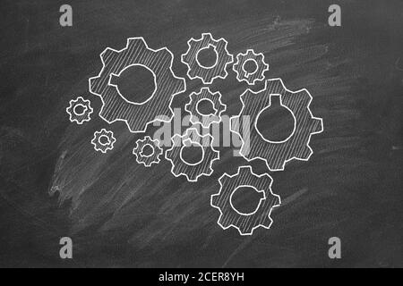 Human brain build out of cogs and gears on blackboard Stock Photo