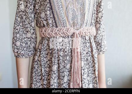 Handmade macrame dress belt. Natural cotton threads and wooden beads. Stylish decoration for women 's dress.  Macrame braiding and cotton threads. Fem Stock Photo