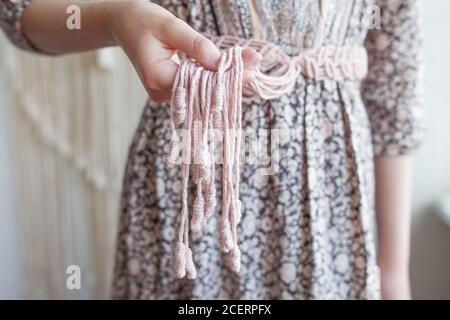 Handmade macrame dress belt. Natural cotton threads and wooden beads. Stylish decoration for women 's dress.  Macrame braiding and cotton threads. Fem Stock Photo