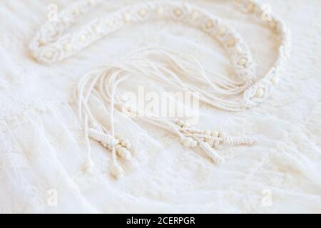 Handmade macrame dress belt. Natural cotton threads and wooden beads. Stylish decoration for women 's dress.  Macrame braiding and cotton threads. Fem Stock Photo