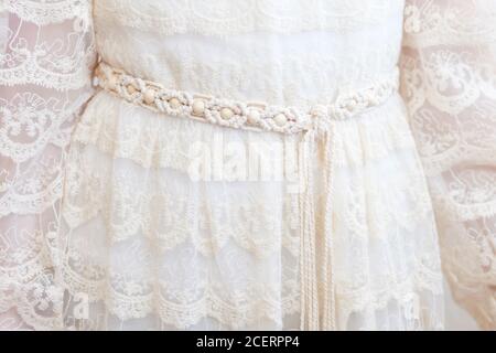 Handmade macrame dress belt. Natural cotton threads and wooden beads. Stylish decoration for women 's dress.  Macrame braiding and cotton threads. Fem Stock Photo