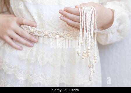 Handmade macrame dress belt. Natural cotton threads and wooden beads. Stylish decoration for women 's dress.  Macrame braiding and cotton threads. Fem Stock Photo